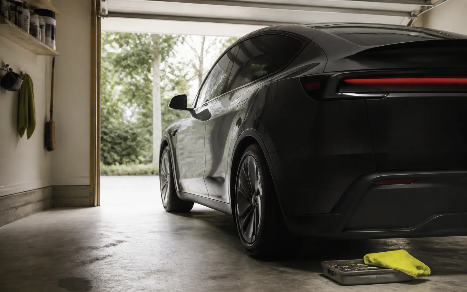 An unbranded dark crossover parked in a small home garage beside a bright microfiber cloth